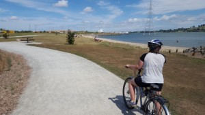 Cycling the new recreational paths along the Onehunga Foreshore - with the new walking and cycling overbridge to Onehunga in the distance.