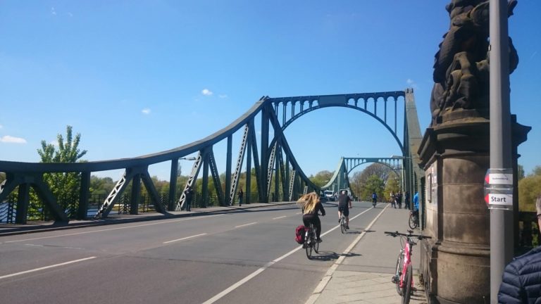 People riding in the bike lane of the bridge.