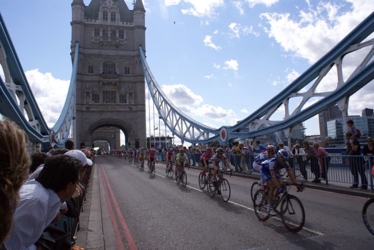 Big group of cyclists riding over Tower Bridge.