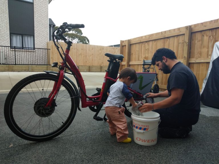 Juan and his child cleaning their bike.