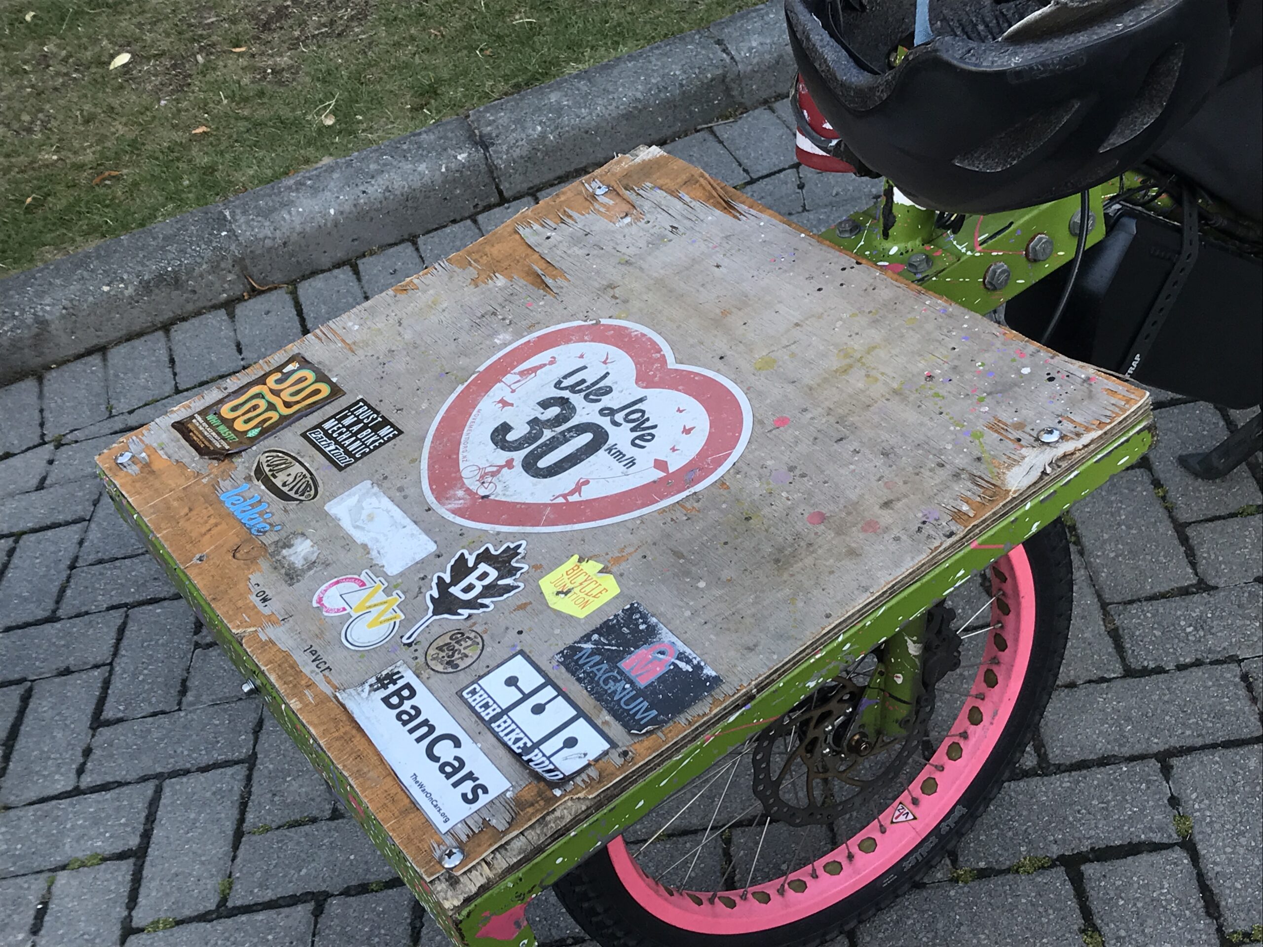 A sticker on a cargo bike says 'we love 30km/hr'. It's designed to look like a road sign except instead of a circle shape it's a love heart. 