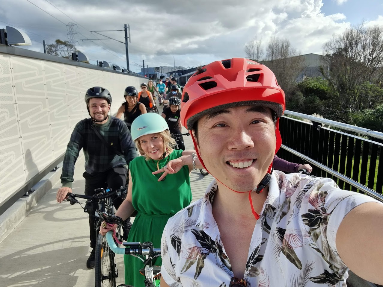 Bobby smiles at the front of a line of people on bikes
