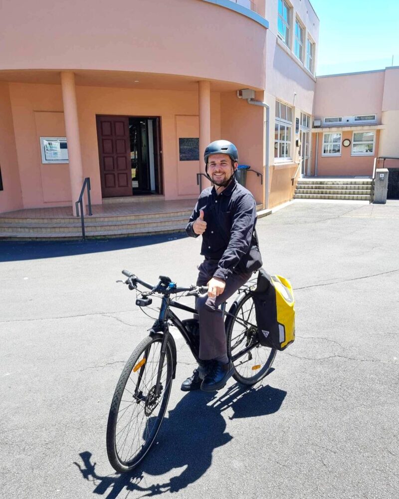 Jon is on a bike giving a thumbs up