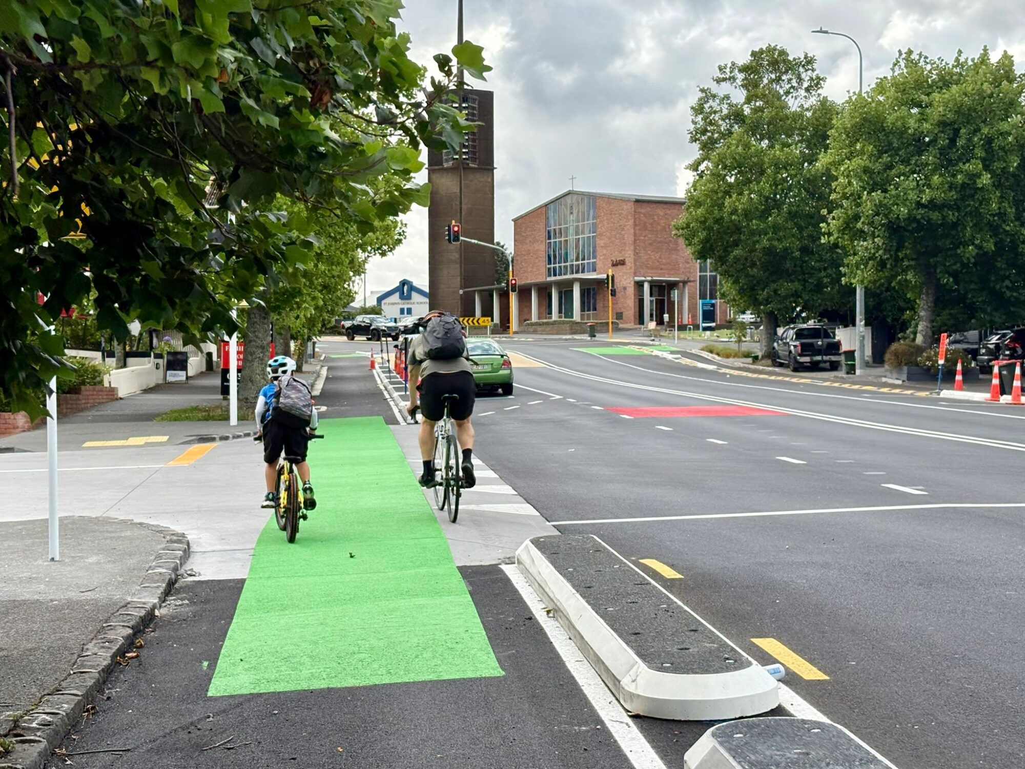 Two people on bikes on a protected urban cycle lane
