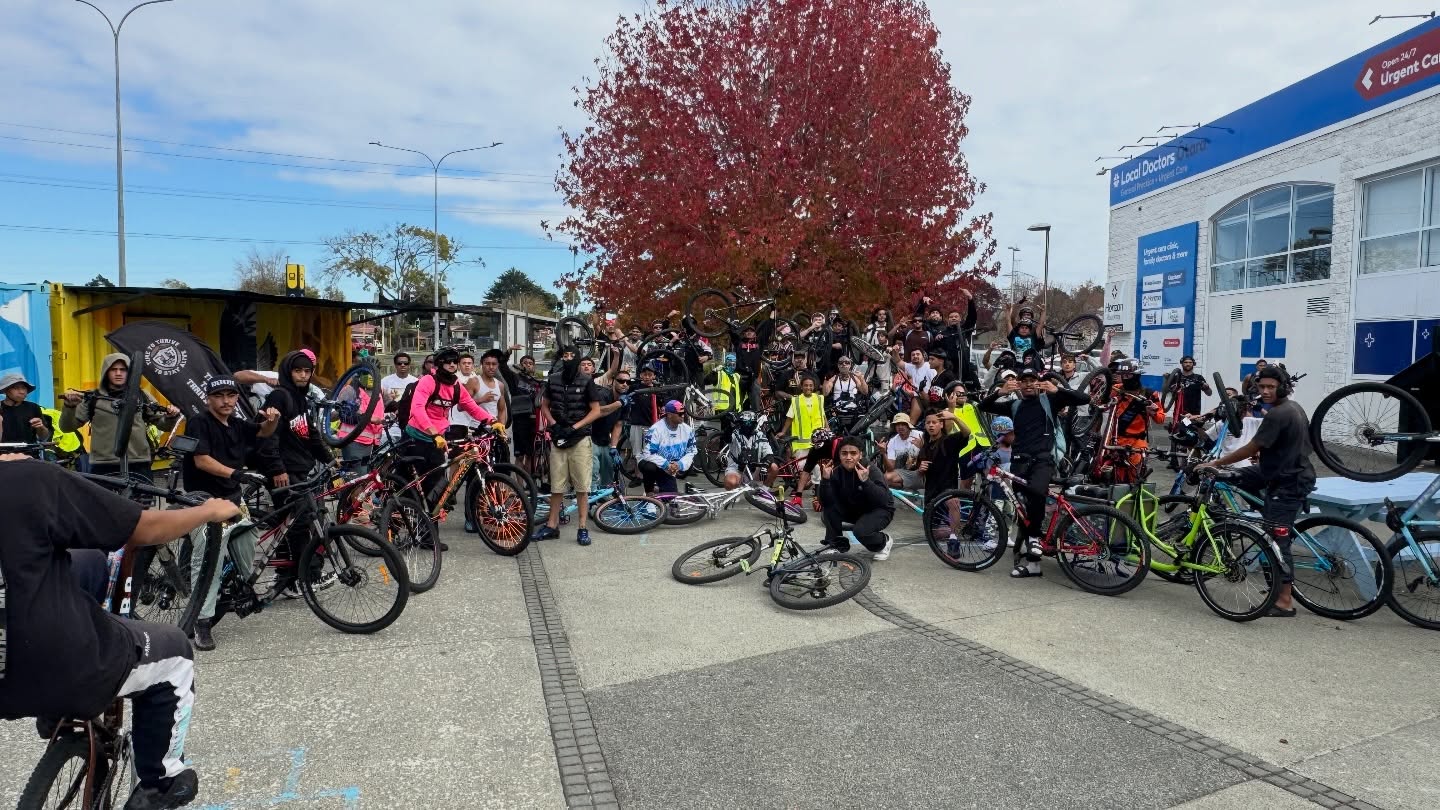 large group of people with bikes pose in semicircle